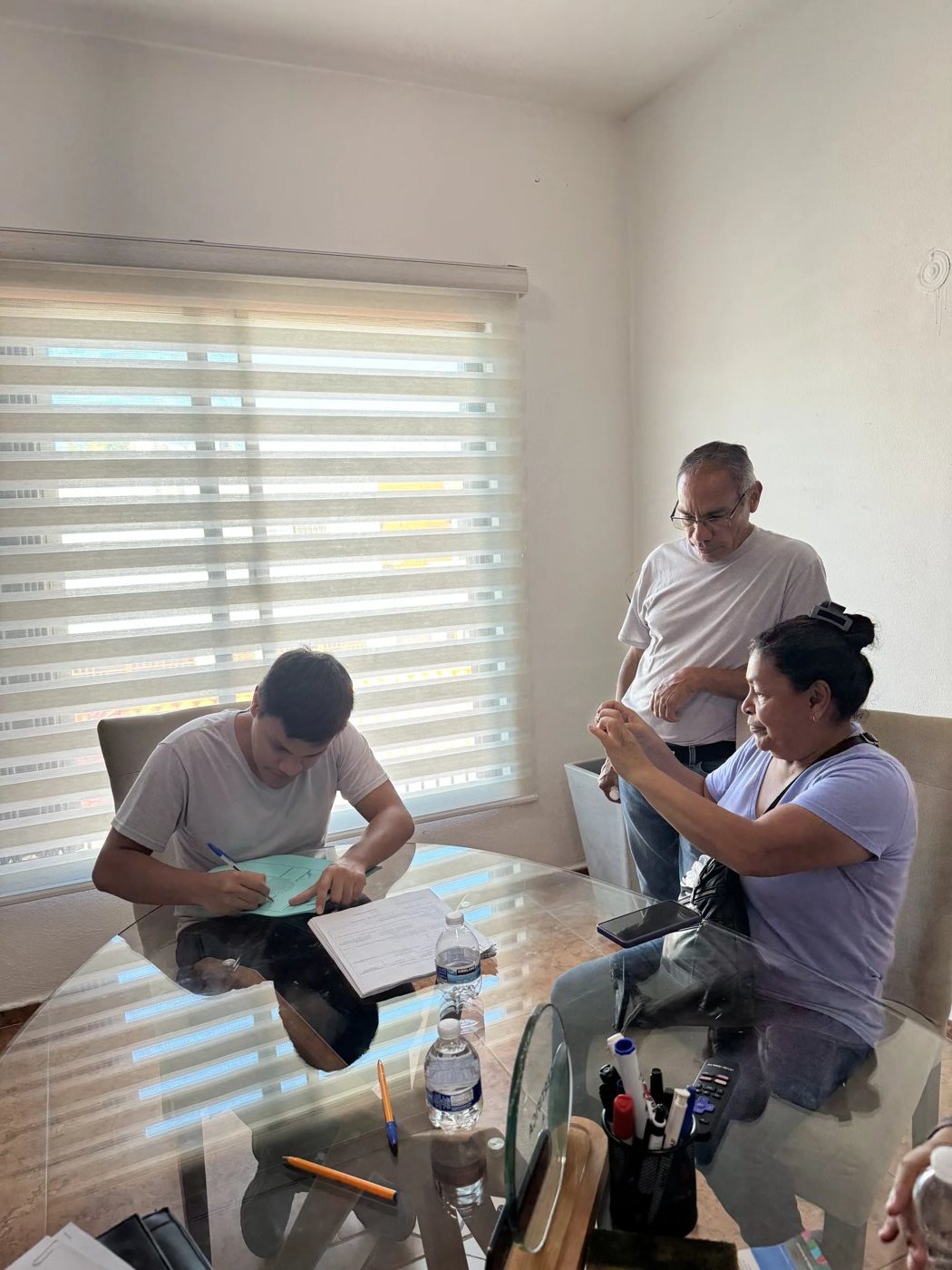 Signing paperwork with buyers at a delivered unit.